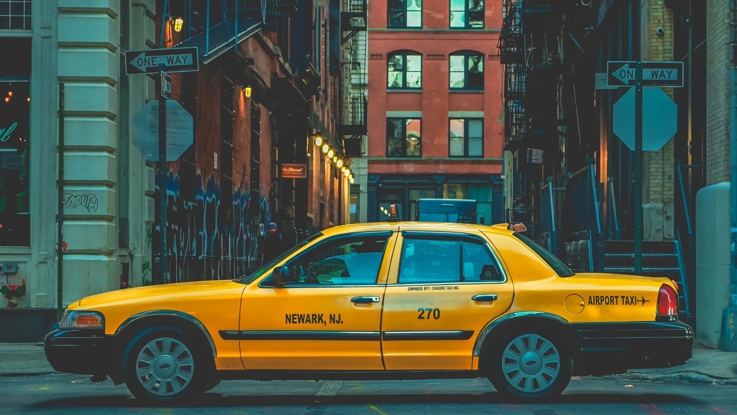 Classic yellow taxi in New York City street, symbolizing urban transport and life.