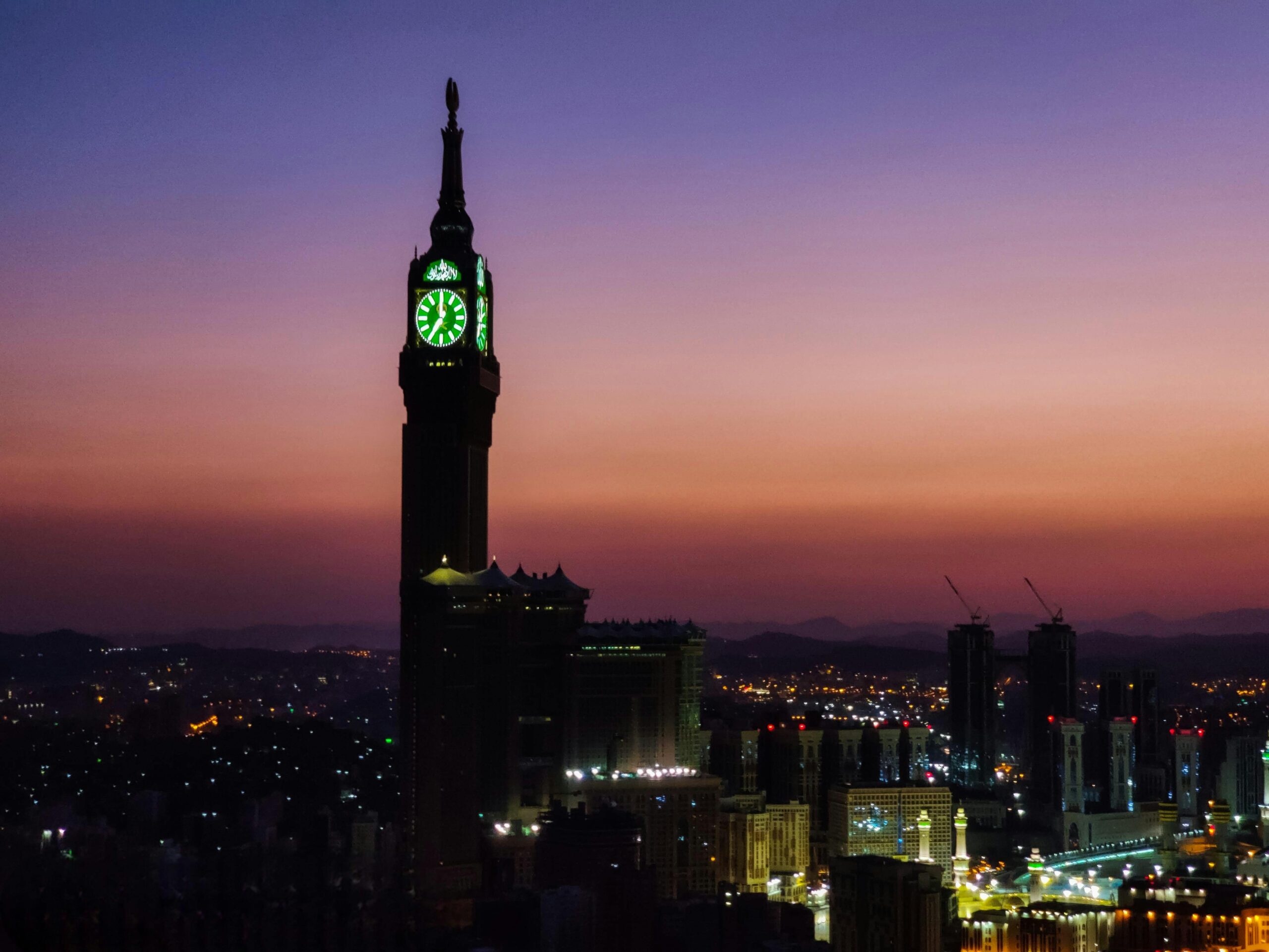 Silhouette of the Makkah Royal Clock Tower at dusk, capturing the vibrant Mecca skyline.