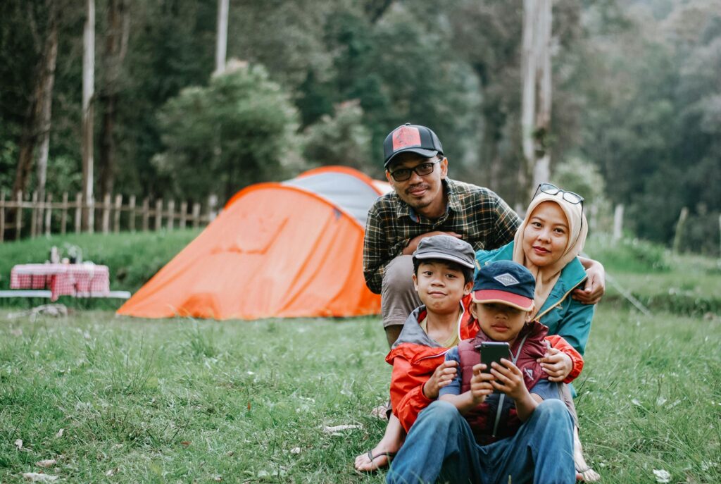 Happy family enjoying a relaxing camping trip in a lush forest setting, perfect for outdoor enthusiast inspiration.